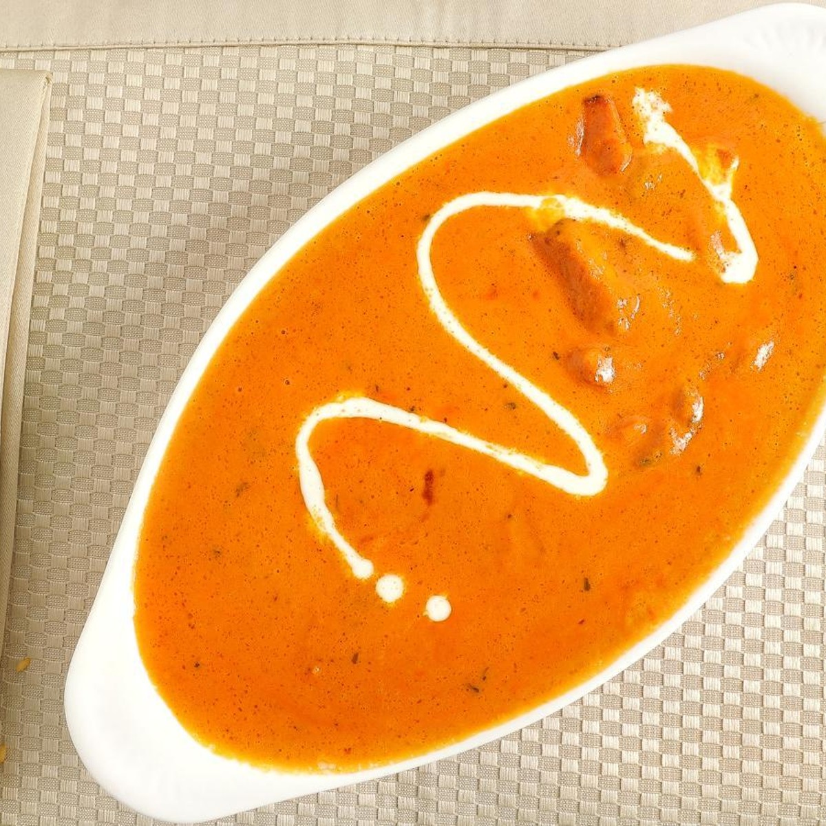 Butter Chicken — Chicken marinated in yoghurt and spices, cooked in tomato puree and cream.